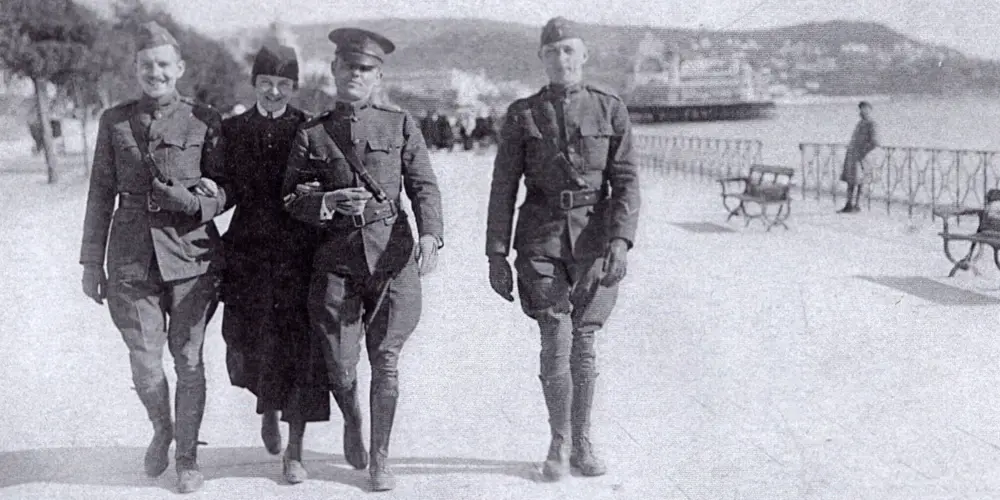 Nursing Sister Ethel Cutter of the American Red Cross walking with three soldiers in France in 1918